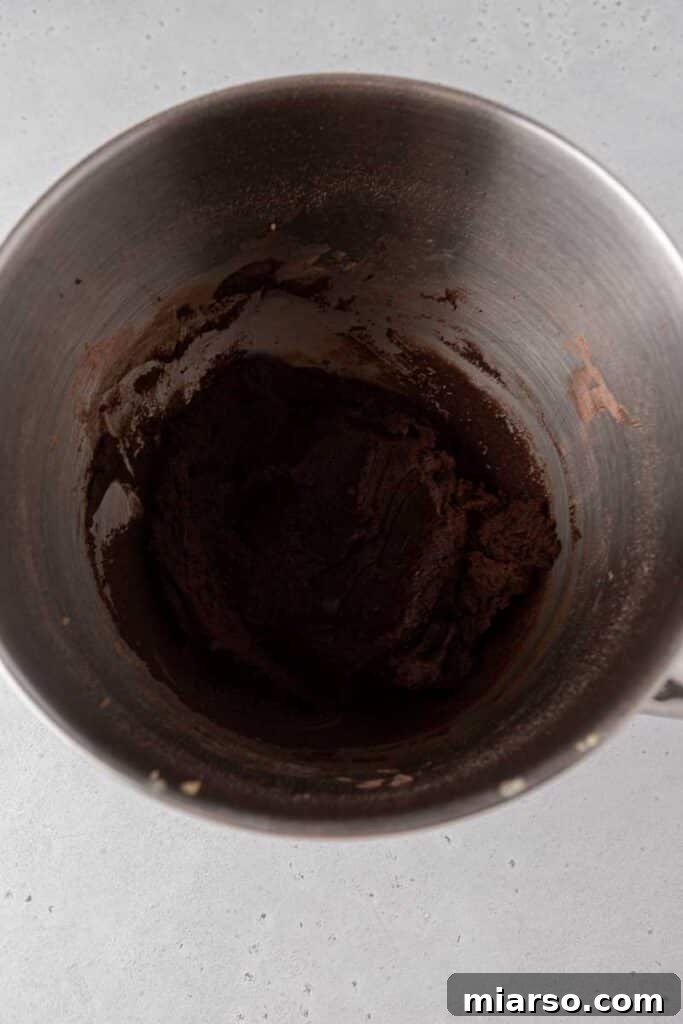 Thick chocolate cookie dough mixed in a stainless steel bowl.
