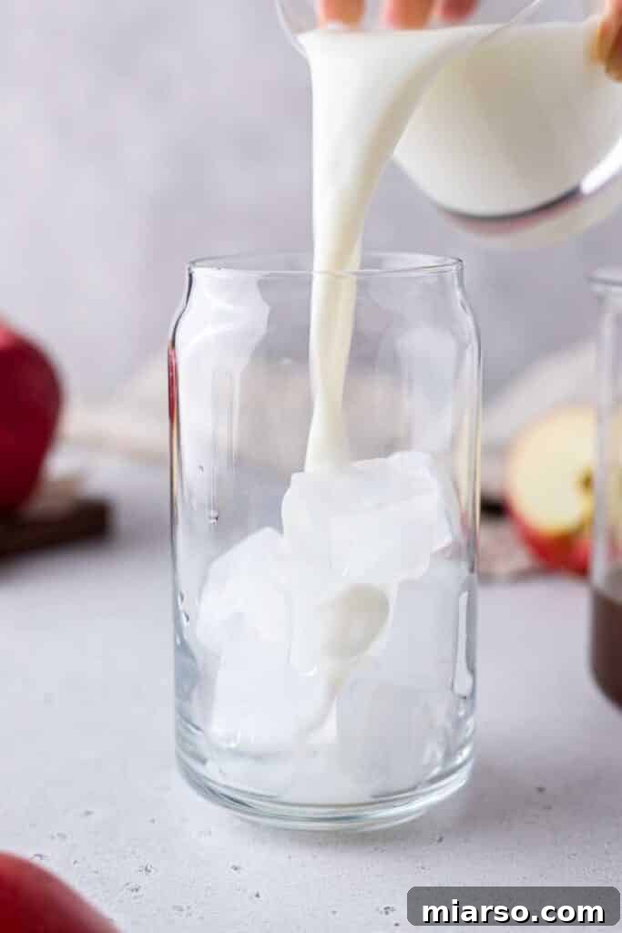 Starbucks Apple Crisp Macchiato 13 Pouring milk into a glass with ice