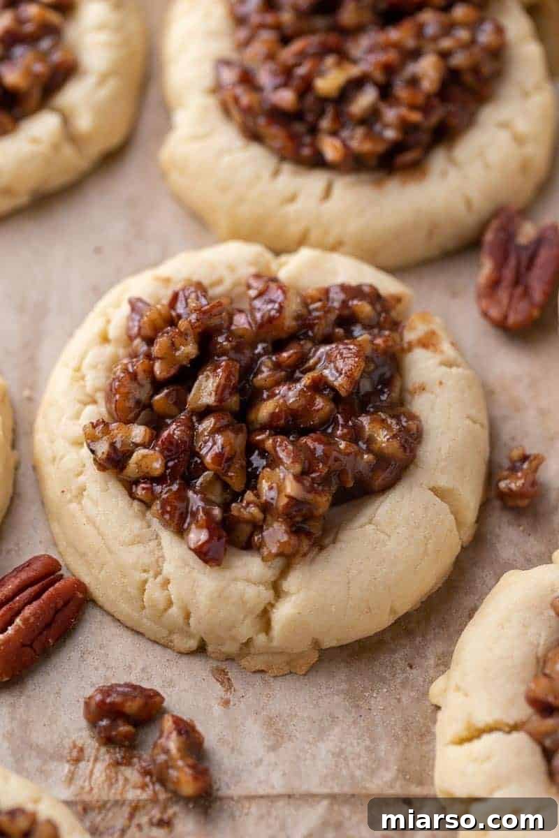 Unlock Crumbl's Secrets: 40+ Copycat Cookie Recipes for 2025 23 Soft Crumbl pecan pie cookies topped with gooey pecan filling on parchment paper