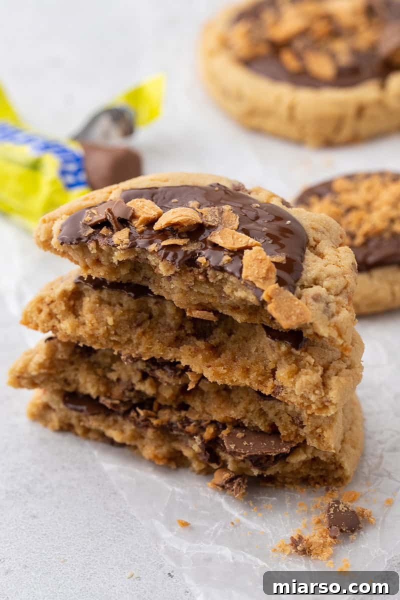 Unlock Crumbl's Secrets: 40+ Copycat Cookie Recipes for 2025 32 Stacked Crumbl Butterfinger peanut butter cookies showing soft chewy center with melted chocolate and crunchy Butterfinger pieces