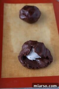 Filling a chocolate cookie with marshmallow fluff