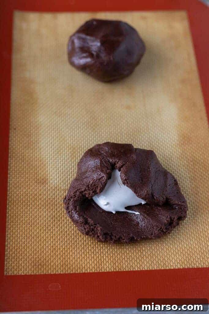 Filling a chocolate cookie with marshmallow fluff