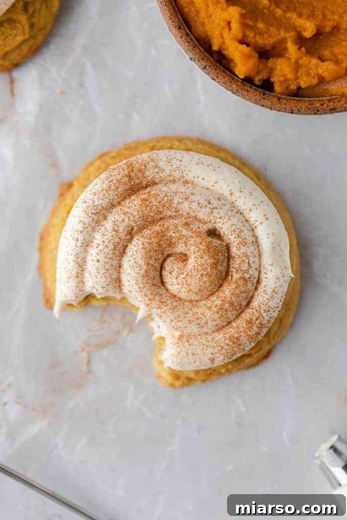 Overhead shot of freshly baked Crumbl caramel pumpkin cookies with creamy frosting and spice.