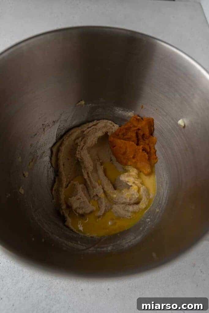 Close-up of butter and sugars being creamed together in a bowl.