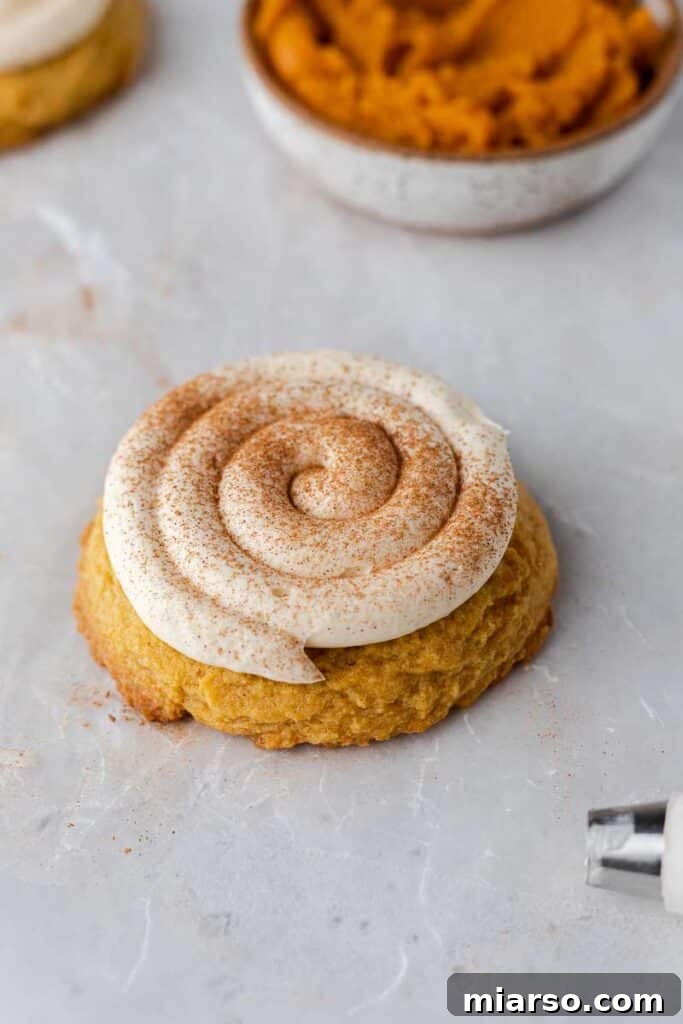 Close-up of a cream cheese frosted pumpkin cookie, ready to eat.