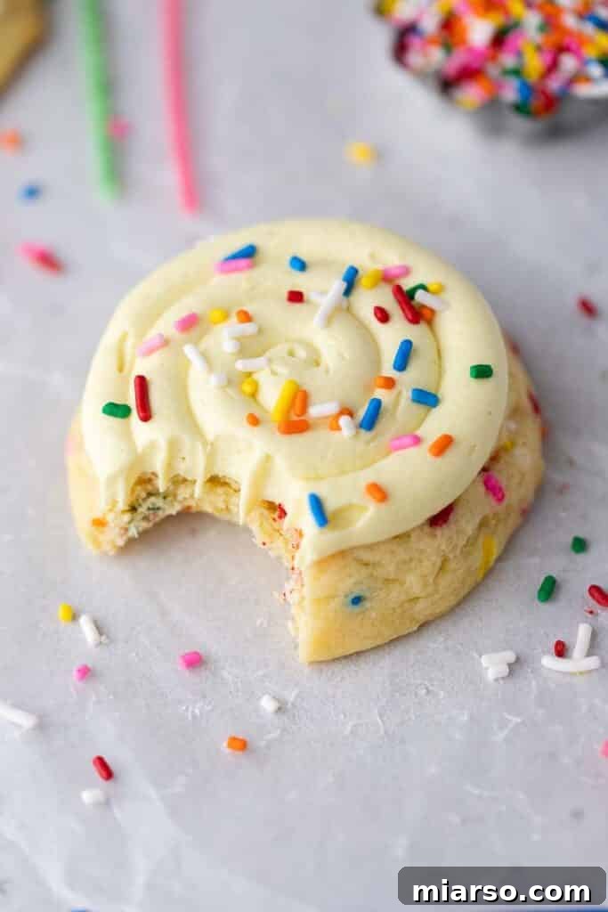 A close-up of a Crumbl birthday cake cookie with a bite taken out, revealing its soft, sprinkle-filled interior