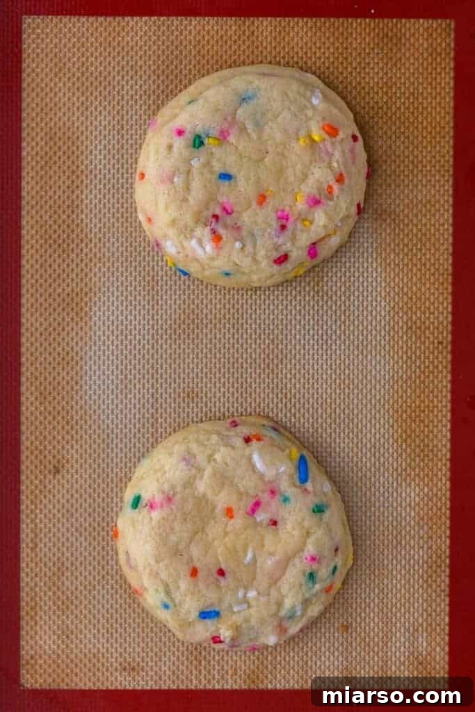 Freshly baked funfetti cookies cooling on a baking sheet
