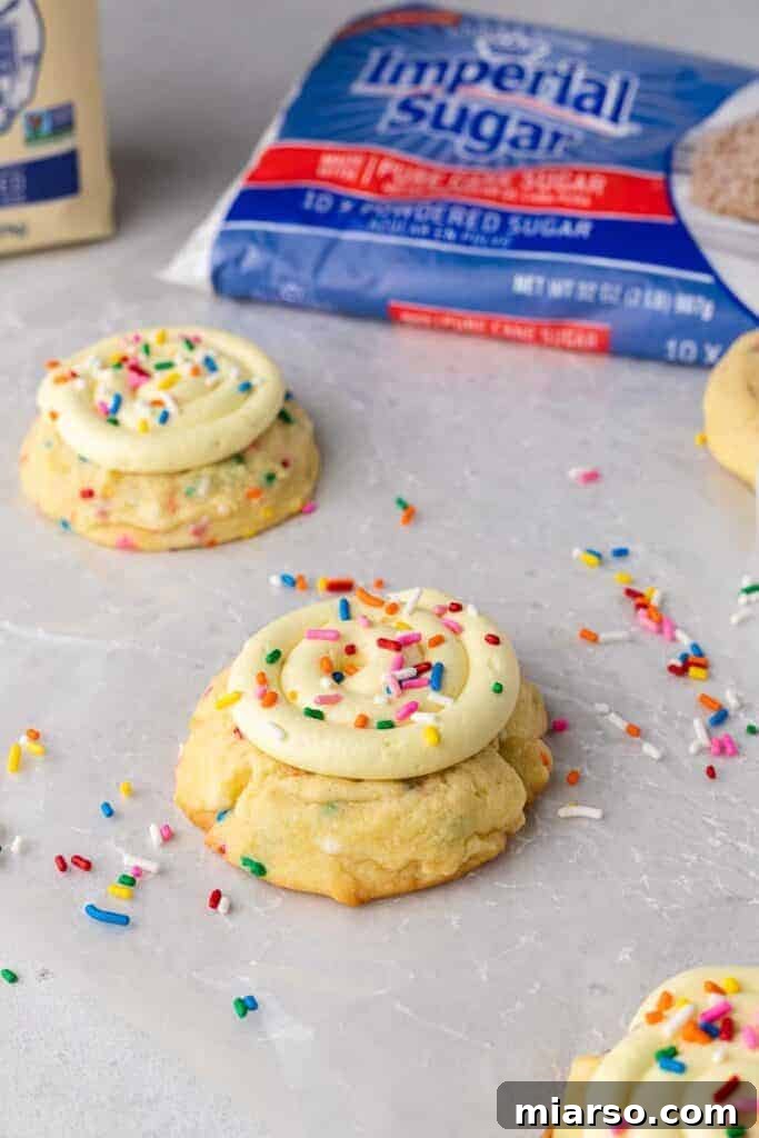 Frosted Crumbl birthday cake cookies garnished with extra sprinkles