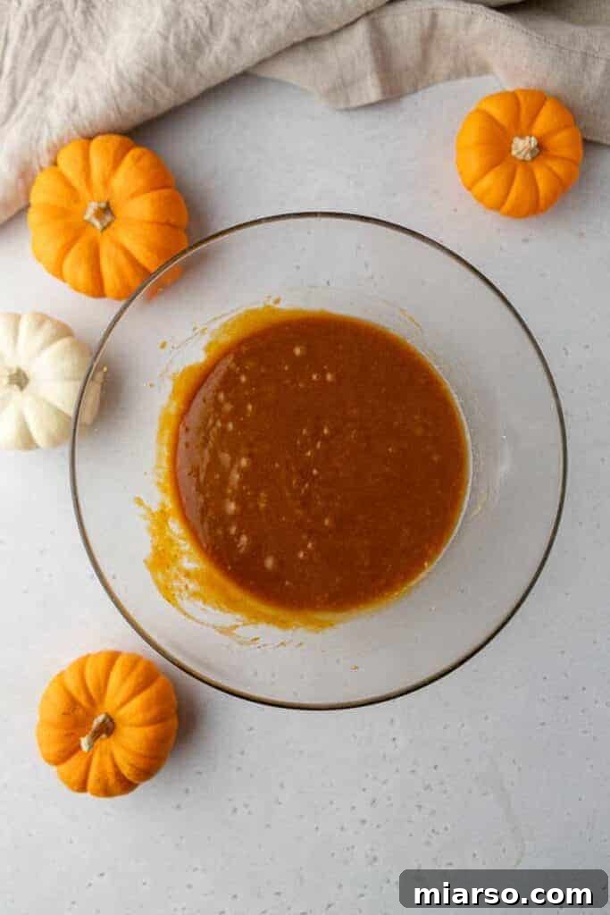Gourmet Pumpkin Chocolate Chip Muffin Top Cookies 5 Whisking pumpkin puree, eggs, and sugars in a mixing bowl