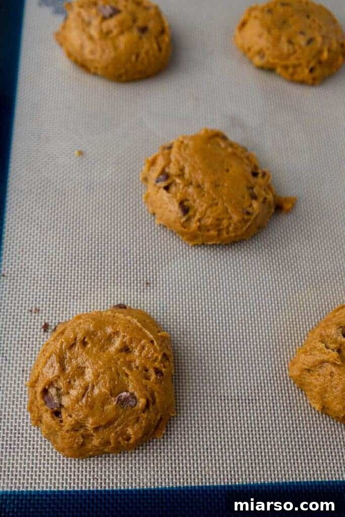Gourmet Pumpkin Chocolate Chip Muffin Top Cookies 7 Portioned pumpkin chocolate chip cookie dough on a parchment-lined baking sheet