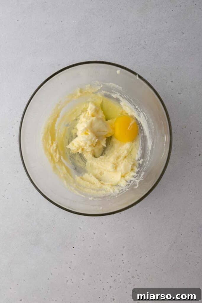 Close-up of creamed butter and egg mixture in a mixing bowl.