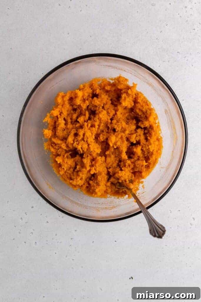 Pecan Pie Twice-Baked Sweet Potato Delight 7 Mash in a bowl with butter cinnamon and maple syrup after mixing.