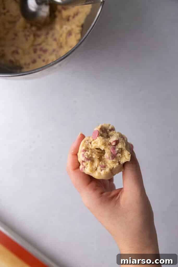 Prepared cookie dough balls on a baking sheet, ready for chilling and baking