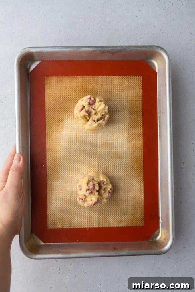 Freshly baked ruby chocolate chip cookies on a baking sheet, just out of the oven