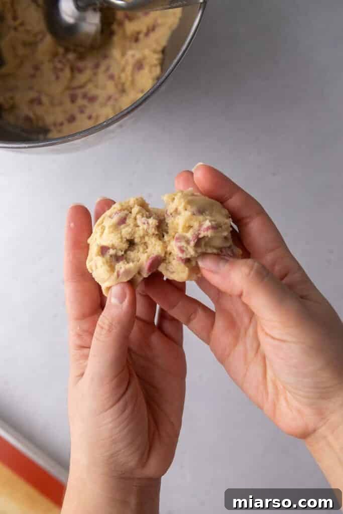 Another angle of ruby chocolate chip cookie dough on a baking sheet, pre-baking