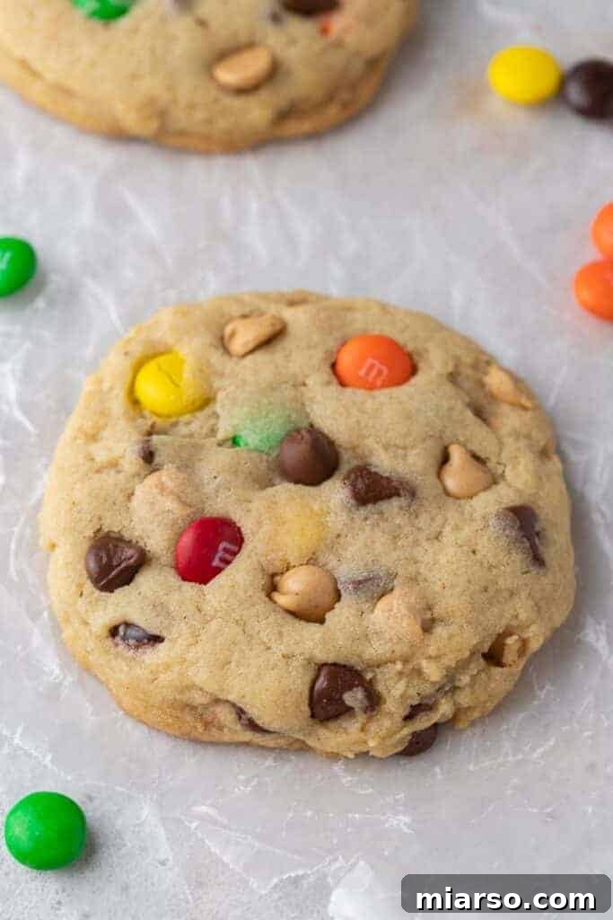 Close-up of a thick and chewy Monster cookie on parchment paper.