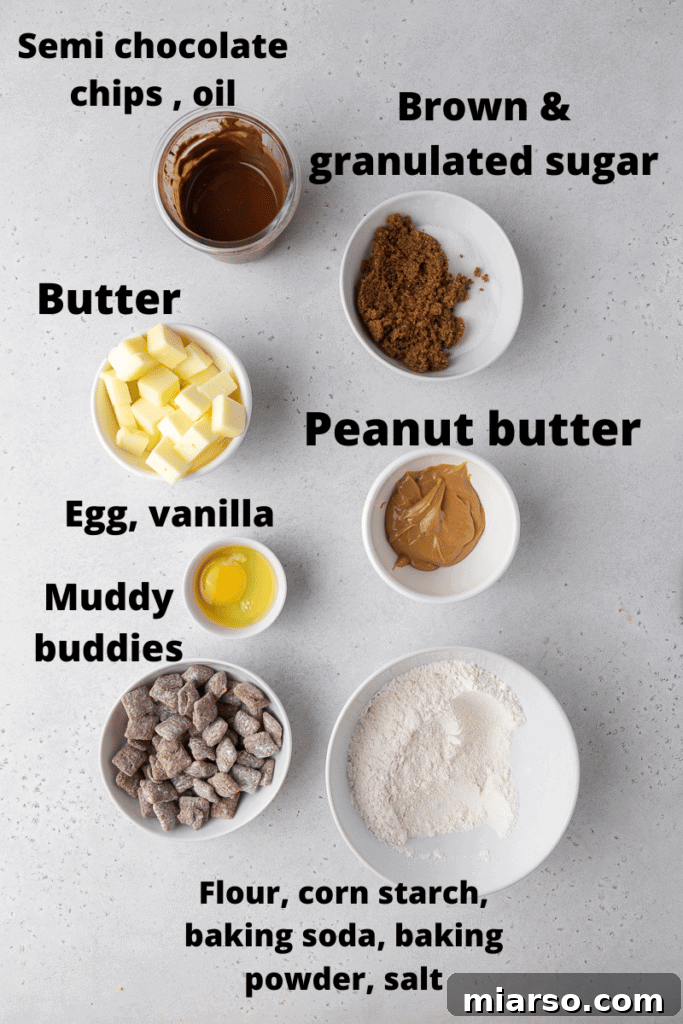 Assortment of ingredients for making Crumbl Peanut Butter Muddy Buddies cookies, including peanut butter, butter, sugars, egg, vanilla, flour, leavening agents, cornstarch, salt, chocolate chips, oil, and Muddy Buddies cereal.