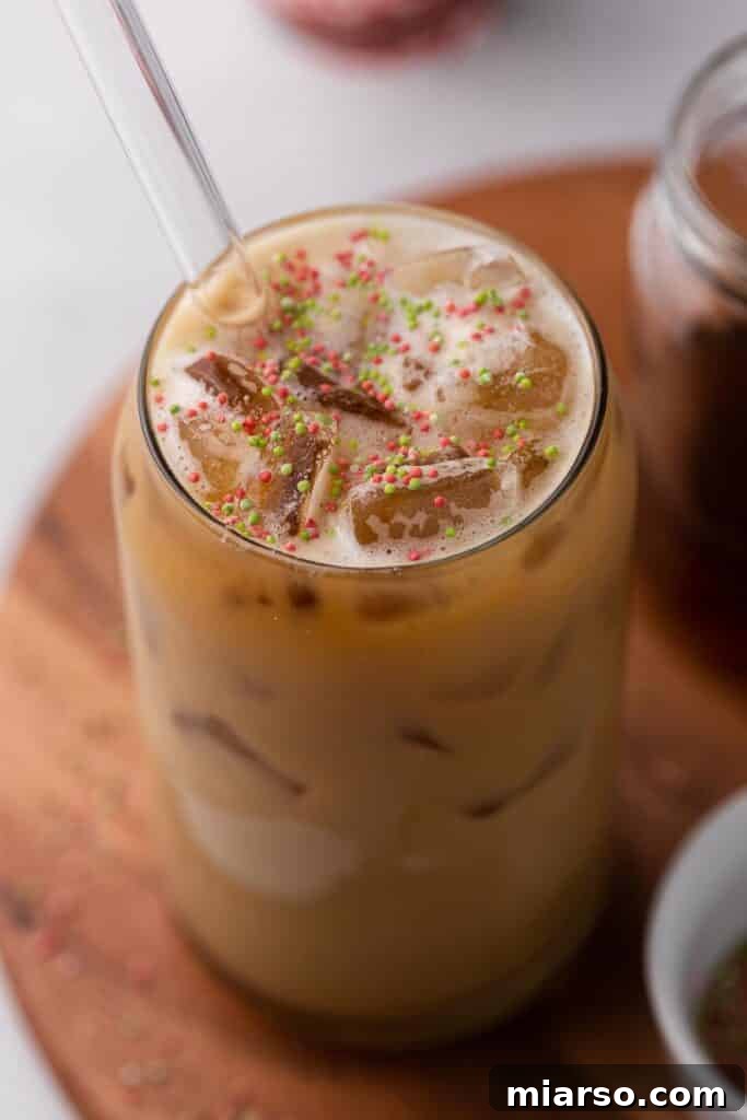 Sweet Almond Sugar Cookie Bliss Starbucks Style 2 A festive Starbucks Sugar Cookie Almond Milk Latte, served in a glass with sprinkles, perfect for the holidays.