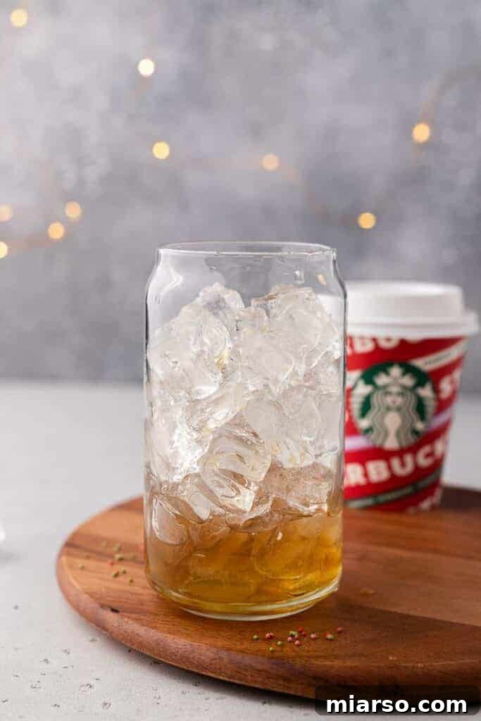 Sweet Almond Sugar Cookie Bliss Starbucks Style 5 Sugar cookie simple syrup poured into a glass with ice, ready for latte assembly.