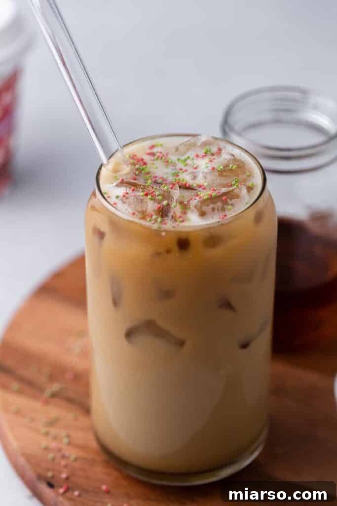 Sweet Almond Sugar Cookie Bliss Starbucks Style 6 A beautifully presented Starbucks iced sugar cookie almond milk latte in a glass, topped with sprinkles.