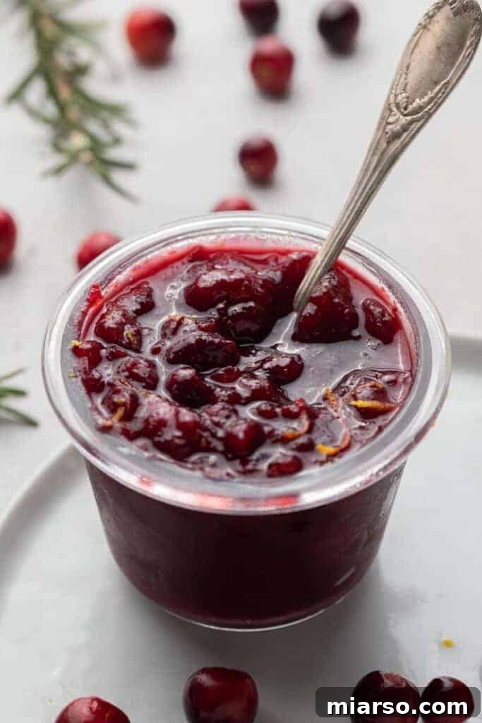 Freshly made orange cranberry sauce in a glass jar, ready for Thanksgiving dinner.