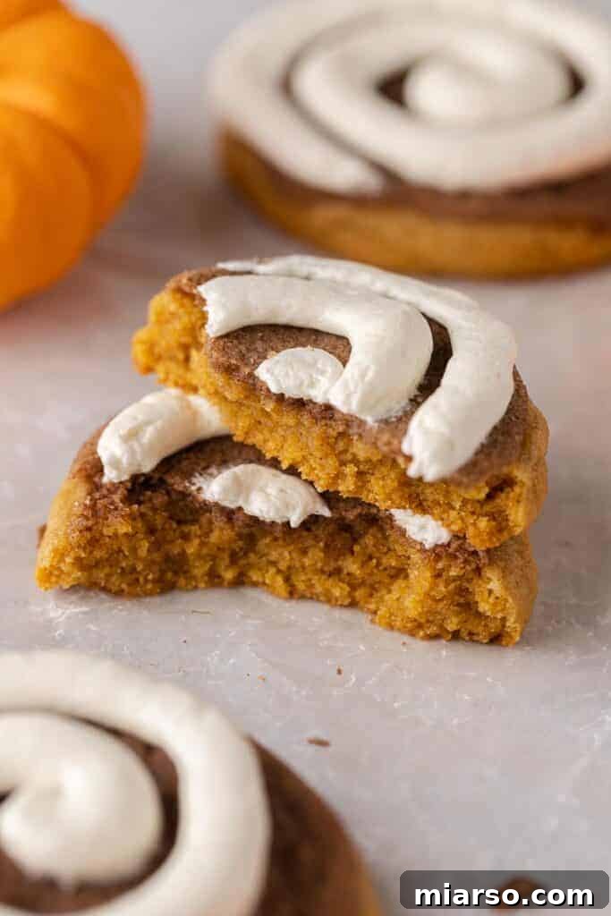 Stacked Crumbl pumpkin swirl cookies, inspired by classic pumpkin rolls.