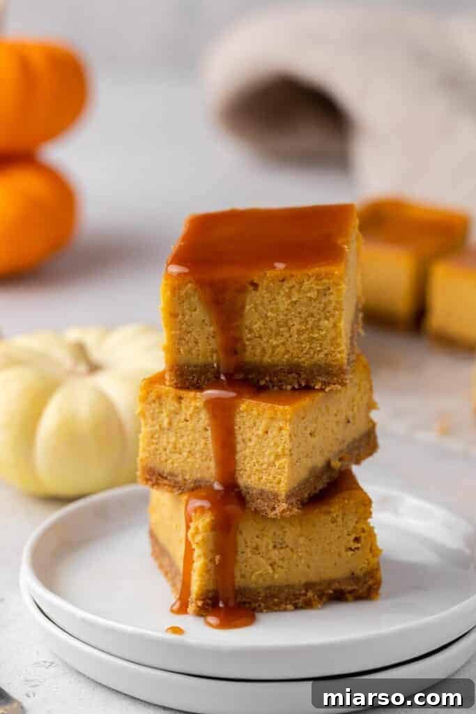 Stack of pumpkin cheesecake bars with caramel, an easy and flavorful Thanksgiving dessert.
