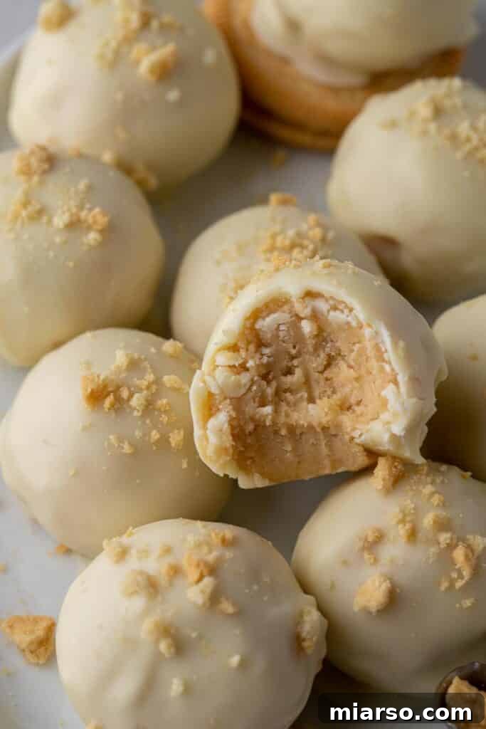 Golden Oreo Cheesecake Truffles 9 Close up of white chocolate truffles with a delicate drizzle.