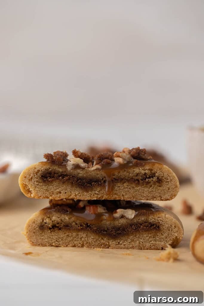 Crumbl Sticky Bun Cookie Perfection 2 Crumbl sticky bun cookie cut in half revealing cinnamon filling
