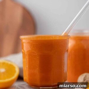 Golden Immunity Zest Smoothie 8 Bright orange ginger carrot orange smoothie in a glass, ready to be served and enjoyed.