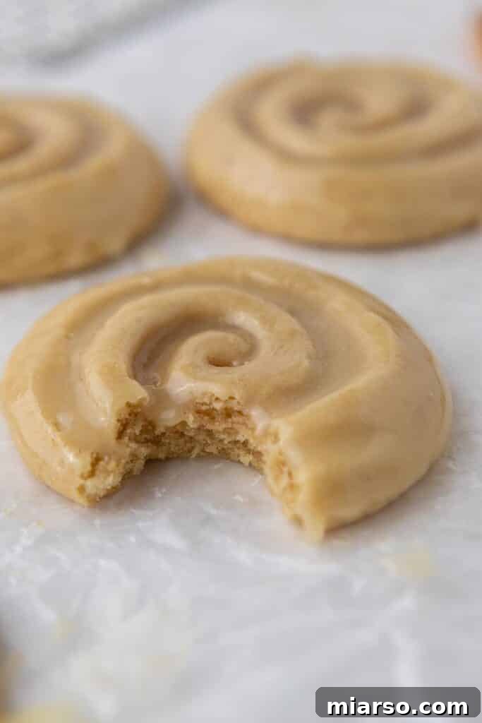 Crumbl honey bun cookie with a bite taken out of it