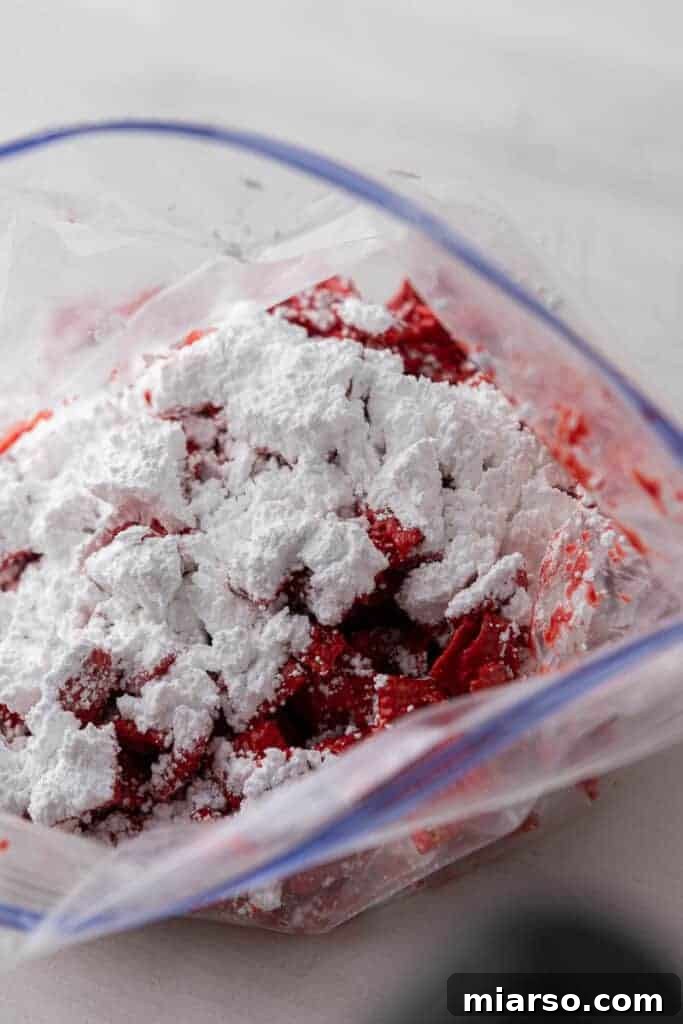 Cupid's Crunch 12 Red muddy buddies in a zip-top bag, coated with powdered sugar.