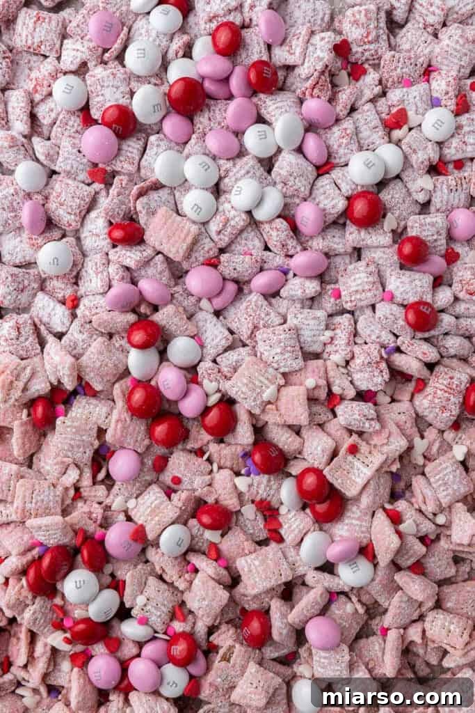 Cupid's Crunch 14 A closer shot of the Valentine's Day puppy chow (muddy buddies) with M&M's and sprinkles on a baking sheet.