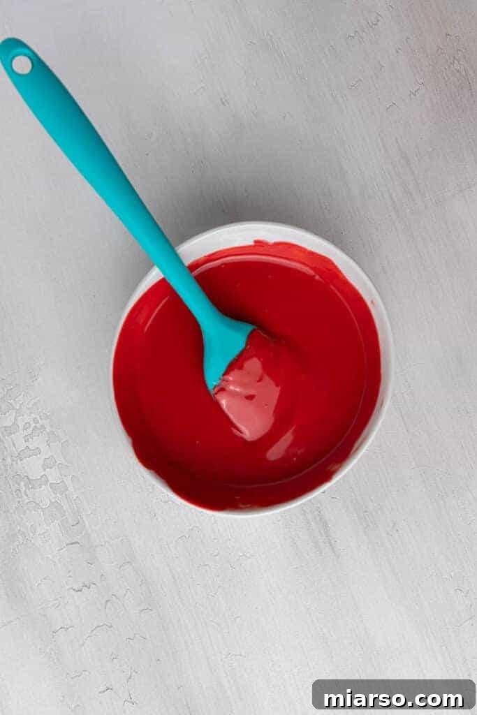 Cupid's Crunch 9 Melted red candy melts in a bowl, smooth and ready to use.