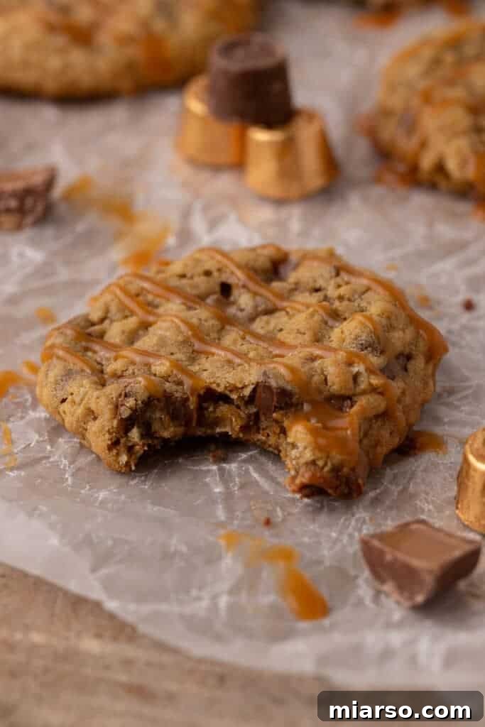 A bite-sized Crumbl Oatmeal Rolo cookie showing its gooey caramel and chocolate center