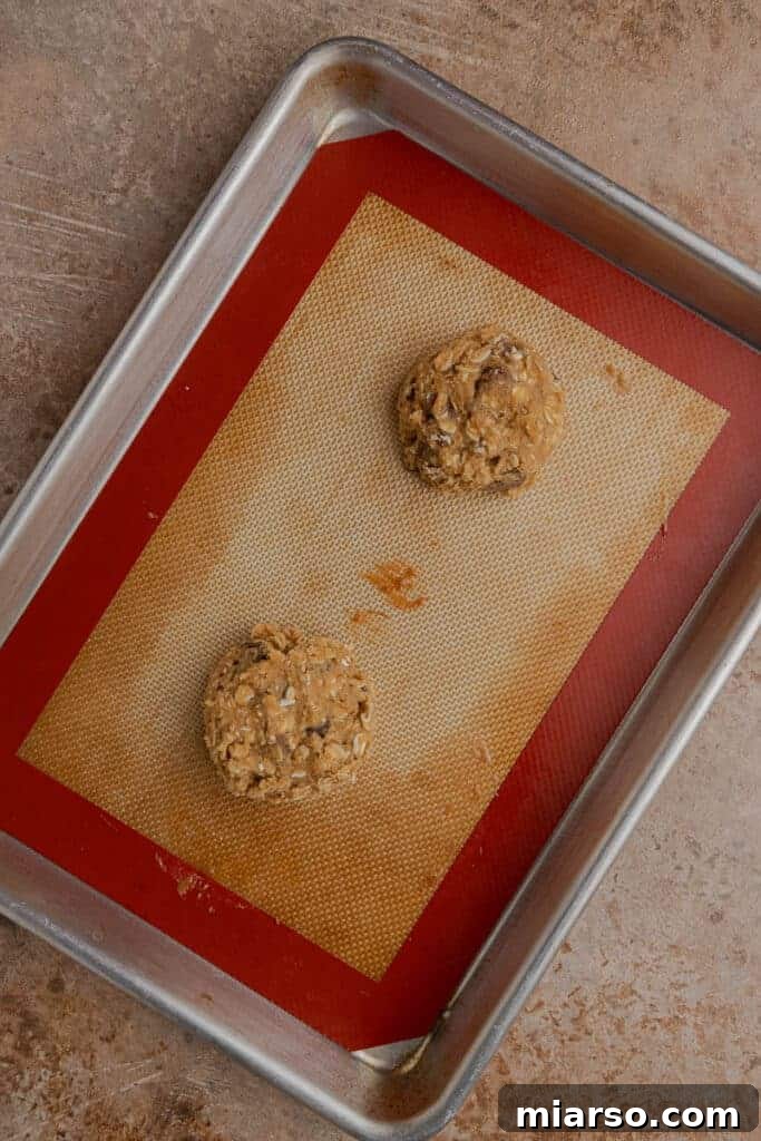 Oatmeal cookie dough balls on a baking sheet before going into the oven