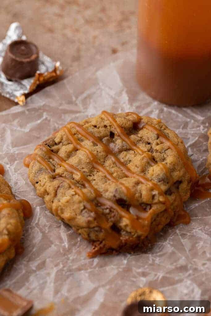 Close up of a Crumbl Rolo Cookie with caramel drizzled on top, showing the melted Rolo inside