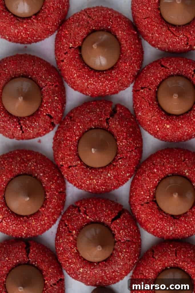Hershey's Kissed Red Velvet Cookies 3 Overhead shot of freshly baked red velvet blossom cookies, coated in red sugar