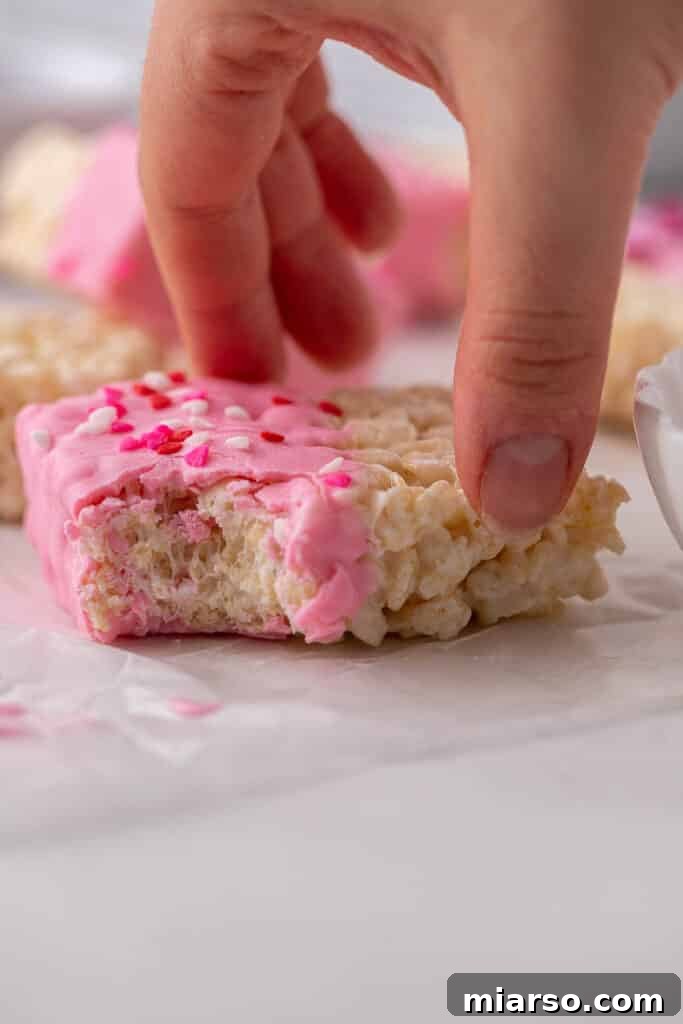 Hand grabbing chocolate covered rice krispie treats