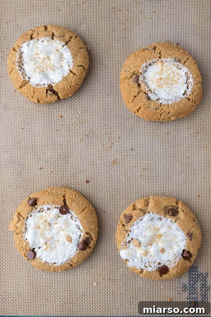 Warm Crumbl S'mores cookies cooling on baking sheet