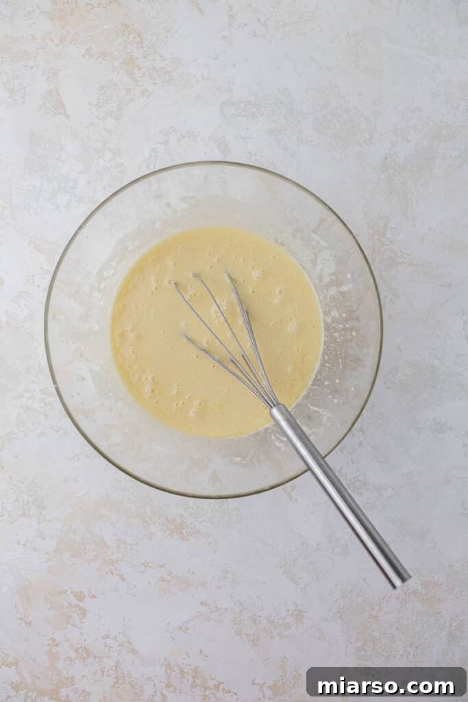 Simply Perfect Buttermilk Waffles 6 Mixing wet ingredients in a bowl
