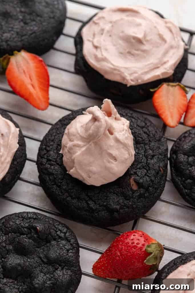 Step 5: Scrumptious chocolate strawberry cheesecake cookies with vibrant pink frosting applied.