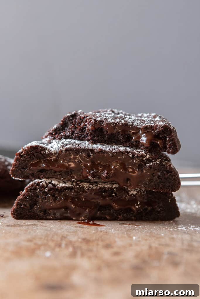 Stacked molten lava cookies with a rich chocolate exterior and oozing molten center