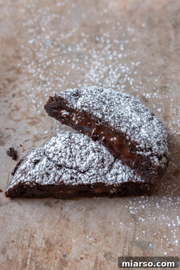 Molten lava cookie broken in half with chocolate sauce oozing out