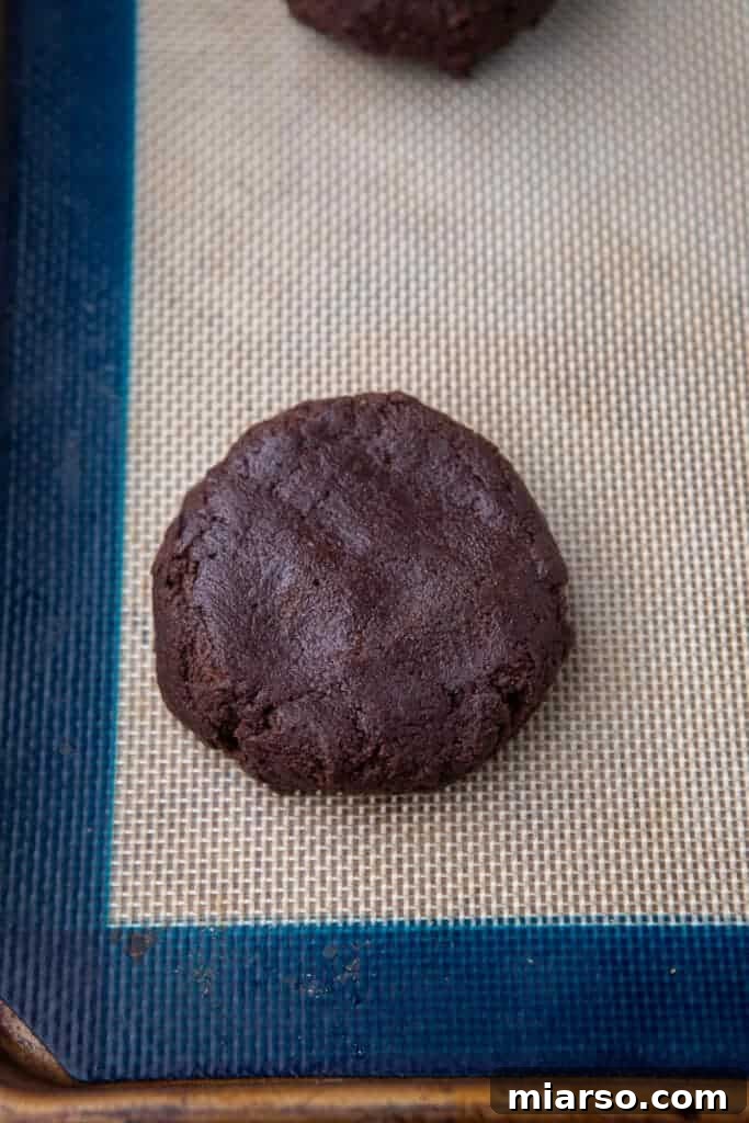 Scooped chocolate cookie dough balls on baking sheet