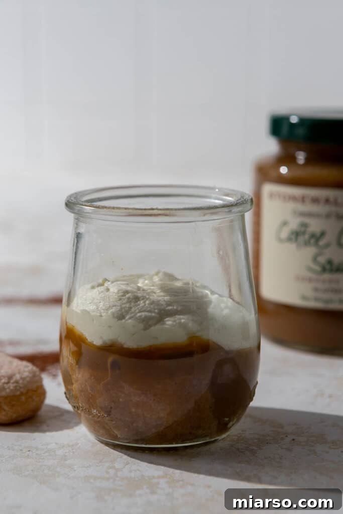 First layer of ladyfingers, caramel, and mascarpone cream in a cup