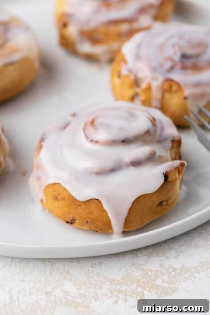 Golden brown air fryer cinnamon rolls, fresh from the appliance, ready to be glazed.