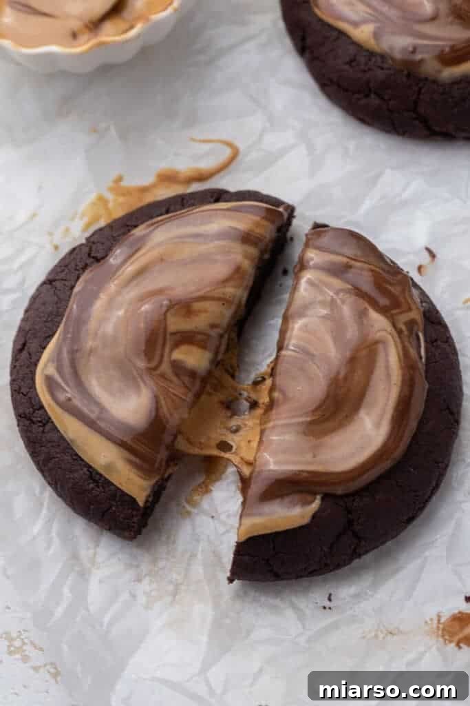 The Ultimate Peanut Butter Brownie Cookies 2 Close up of a homemade peanut butter brownie cookie broken in half, revealing the soft peanut butter filling