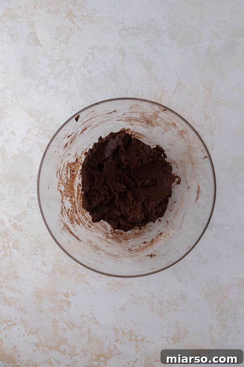 The Ultimate Peanut Butter Brownie Cookies 6 Rich chocolate cookie dough prepared in a mixing bowl, ready for shaping