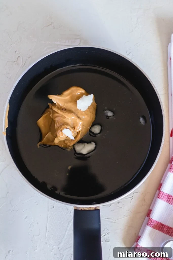 Coconut oil and peanut butter melting in a saucepan